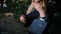 Blond lady is smoking white cigarette outdoors