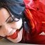 Jill tied and gagged lying on a sofa wearing a sexy shiny red adidas shorts and a red rain jacket (Pics)