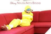 Mara tied, gagged and hooded with tape on a red sofa wearing shiny yellow rainwear (Pics)