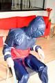Katharina tied and gagged in a shiny nylon rainsuit