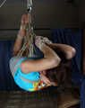 Barefoot Roxana, suspended with ropes, is tickled and teased by a camera man