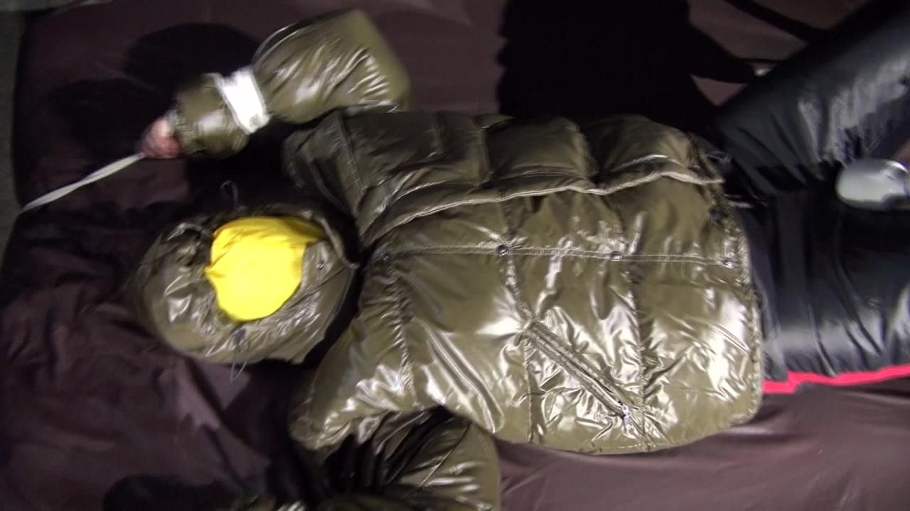 Watching Jill Being Tied On A Bed Wearing A Shiny Nylon Rain Jacket And A Down Jacket As Well As A Rain Pants Being Double Hooded And Gagged With A Ballgag (Video)