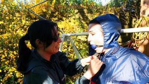 Jill tied and gagged by her friend outside in shiny rainwear