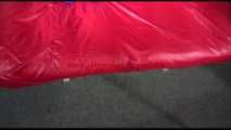 Sonja tied and gagged with ropes and a ballgag on a bed covered with a red shiny nylon cloth wearing a blue shiny nylon rain pants and a purple rain jacket (Video)