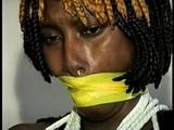 21 Yr OLD BLACK COLLEGE STUDENT GETS MOUTH STUFFED, WRAP TAPE GAGGED WHILE TIED TO A CHAIR  WEARING BLACK LINGERIE, GARTER BELT & HIGH HEELS (D65-4)