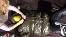 Watching Jill being tied on a bed wearing a shiny nylon rain jacket and a down jacket as well as a rain pants being double hooded and gagged with a ballgag (Video)