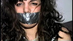 35 YEAR OLD ITALIAN HAIRDRESSER IS DUCT TAPE GAGGED, HANDGAGGED, ROPE TIED, BLINDFOLDED & WEARING A GARTER BELT AND NYLON STOCKINGS (D68-9)