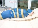 Beautiful archive girl in a blue shiny nylon rainsuit tied and gagged with tape on a sunlounger (Pics)