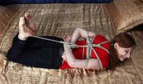 Ballgagged barefoot Tammy in red t-shirt and black jeans, hogtied with hemp rope