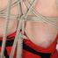 Topless girl secured to the ceiling