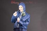 Mara posing in the studio wearing a blue rain skirt and a blue rain jacket as wellas red rubber boots (Pics)