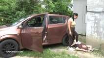 Mistress Jenna stands on the slave with a car while smoking in the slave's mouth A