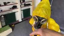 See Lady M, bound in shiny yellow Rainsuit, wearing a latex Mask and a Gasmask