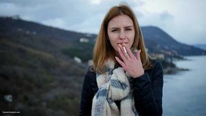 Beautiful lady is smoking two Saratoga cigarettes in a row on a beautiful view