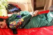 Lucy tied and gagged on bed wearing a sexy green rainwear combination (Pics)