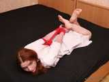 Barefoot nurse Gatitta tied up with a red rope