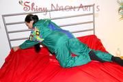 Lucy putting on linen on bed wearing supersexy green shiny nylon rainwear (Pics)