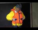 Sexy Mara trying on her new yellow down jacket and her lifevest in combination with a sexy shiny black rain pants and rubber boots (Video)