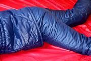 Pia hooded, tied and gagged on bed in a dark blue old school down ski suit