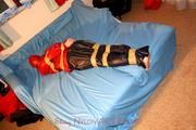 one of our archive girls tied and gagged in shiny nylon rainwear