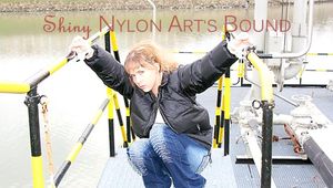 An archive girl tied and gagged on a stair rail wearing a jeans and a shiny down jacket (Pics)