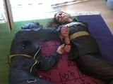 Two archive girls tied and gagged with tape on the floor wearing shiny nylon rainwear (Video)