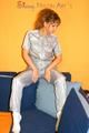 Leonie posing on a sofa wearing a grey adidas shiny nylon rainwear (Pics)