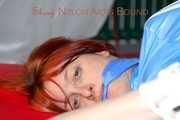 Sonja tied and gagged on bed with ropes wearing a sexy lightblue shiny nylon shorts and a lightblue rain jacket (Pics)