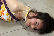 Barefoot Karen in top and shorts, suspended side-ways with hemp rope