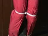one of our archive girl tied and gagged in a shiny nylon rainsuit