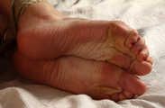 Ballgagged nude barefoot Alberta, hogtied with hemp rope, wiggles and rolls on the bed