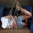 Barefoot Christy in white t-shirt and jeans shorts, suspended sideways, is being played with camera man