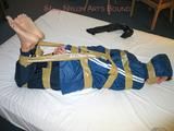 One of our archive girls bound and gagged in a blue shiny rainsuit 