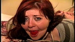 23 YR OLD REAL ESTATE BROKER IS RING GAGGED, DROOLING, BALL-GAGGED , BANDANNA & SCARF CLEAVE GAGGED HANDGAGGED, STINKY SOCK STUFFED IN MOUTH AND HOG-TIED ON BED (D74-2)