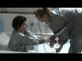 Simone  with an shiny silver PVC sauna suit tied and gagged by Sophie in an bath tub (Video)