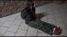 Jill tied, gagged and hooded on a cellar floor wearing a shiny green rain pants and a shiny black down jacket (Video)