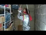 a video with Nicole tied and gagged in a shiny silver PVC sauna suit