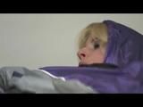 Pia bound and gagged on bed in a shiny purple/silver PVC sauna suit (Video)