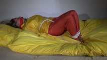 Watching Sandra  wearing an orange shiny nylon rain pants and a yellow shiny nylon rain jacket being tied and gagged on a bed with ropes and a clothgag (Video)