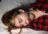 Ballgagged barefoot Carolyn, hogtied with hemp rope, wiggles on the bed