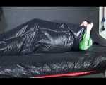 Lucy wearing a green shiny nylon shorts and a green rain jacket lolling on bed (Video)