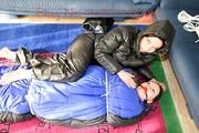 An archive girl tied and gagged in a sleepingsack by Jill on the floor both wearing shiny down jackets (Pics)