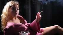 Blonde girl is smoking a cigarette is the dark room