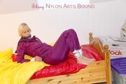 Pia in a shiny purple rainsuit tied and gagged in bed (Pics)