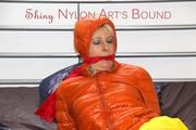 Pia tied and gagged on bed wearing a yellow rain pants and an orange downjacket (Pics)