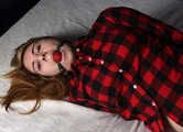 Ballgagged barefoot Carolyn, hogtied with hemp rope, wiggles on the bed