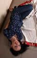 Emily in violet short-sleeve and jeans, hog-cuffed with steel cuffs, wiggles on the floor