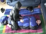 02:45 Min. video with a girl tied and gagged in a skisuit and a big shiny nylon bag to lie in from our archive