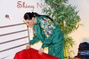 Lucy putting on linen on bed wearing supersexy green shiny nylon rainwear (Pics)