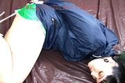 Jill tied, gagged and hooded in bed wearing a sexy green shiny nylon shorts and a shiny rain jacket (Video)